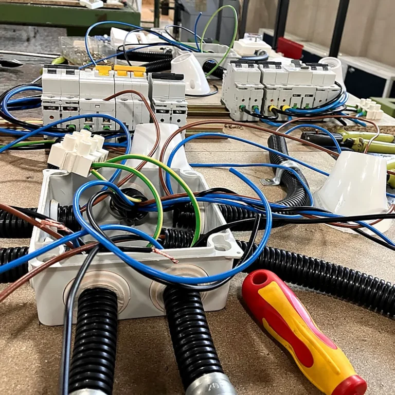 alt="Instalación eléctrica en taller con cajas de derivación, tubos corrugados y magnetotérmicos"