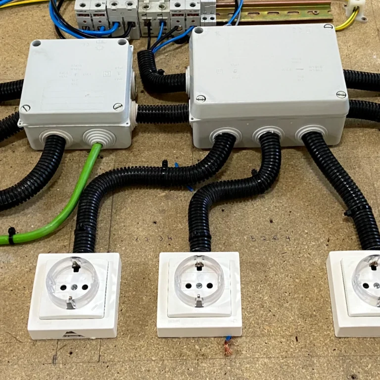 lt="Instalación eléctrica en taller con cajas de derivación, tubos corrugados, bases de enchufes y magnetotérmicos"